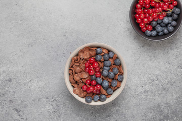 Chocolate corn flakes in a bowl with milk and berries. Delicious healthy Breakfast.