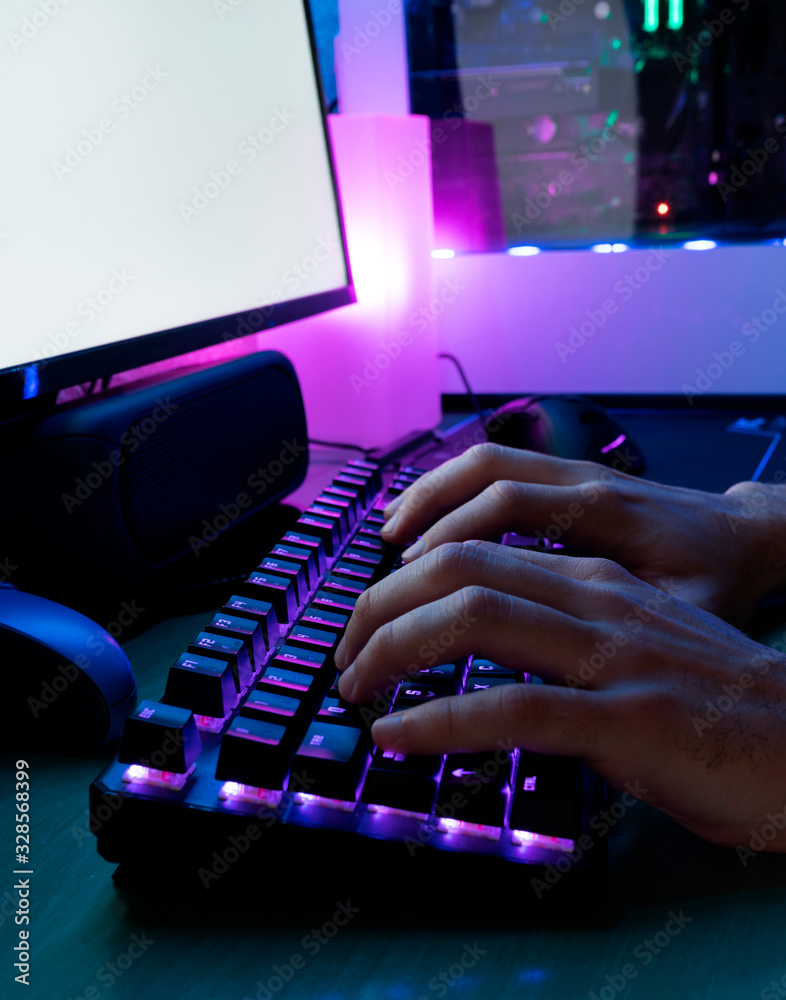 Wall mural image of man's hands typing. hands of a player on a keyboard. background is lit with led lights.