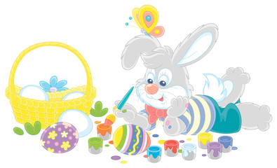 Happy little bunny painting beautiful Easter eggs with bright and colorful paints and an art paintbrush, vector cartoon illustration on a white background