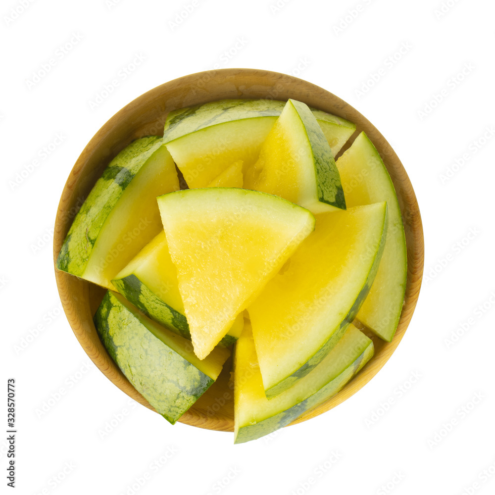 Wall mural heap of slices yellow watermelon in wooden plate isolated on white background