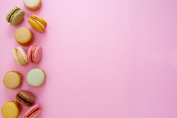 Colorful abstract pink background with french macaroons cookies, copy space. Feminine or beauty background.
