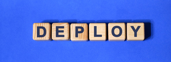 Deploy word on wooden cubes on a blue background