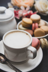 Cup of coffee and macaroons on colorfu lyellow background.