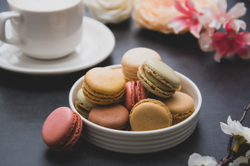 Cup of coffee and macaroons on colorful black background. top view.
