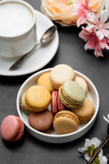 Cup of coffee and macaroons on colorful black background. top view.