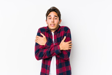 Young caucasian man posing in a pink background isolated going cold due to low temperature or a sickness.