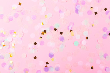 Falling colorful confetti on pink background. Perfect festive background. Flat lay, top view.