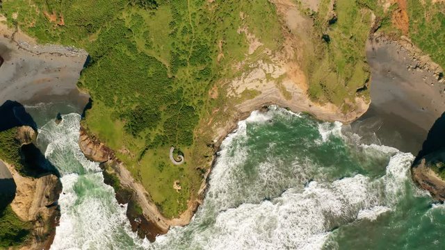 aerial view of the dock of time in the archipelago of chiloe with the waves of the pacific ocean hitting the rocks