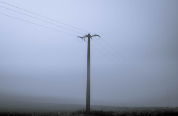 close up electric pole in winter mist