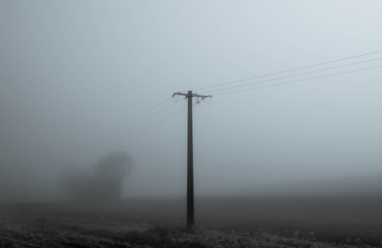 close up electric pole in winter mist