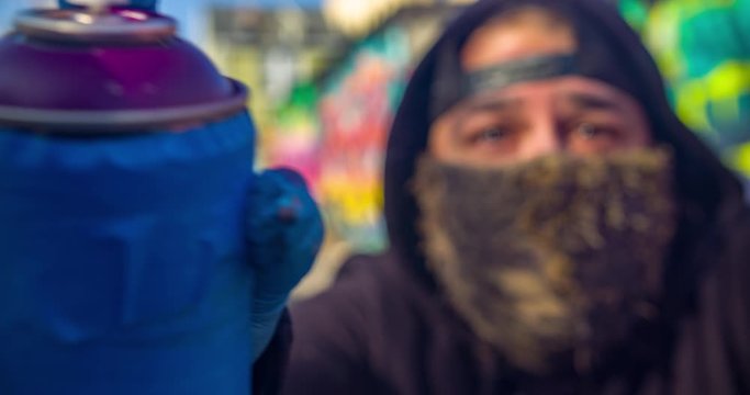 Graffiti artist spray painting in alley, filmed in 4K RAW