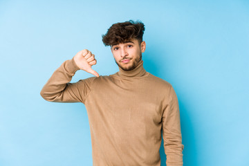 Young arabian man isolated showing a dislike gesture, thumbs down. Disagreement concept.