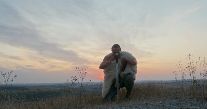 Swordsman wearing a sheepskin planting his sword