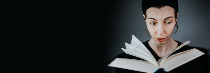 Junge Frau liest begeistert in einem Buch 
