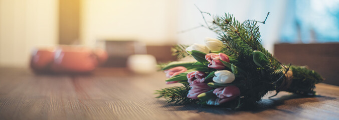 Spring bouquet of tulips lies on the table in the evening. March 8