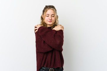 Young caucasian woman on white backrgound hugs, smiling carefree and happy.