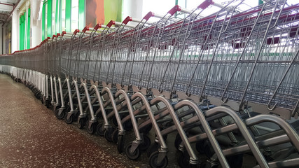 baskets in the supermarket. empty shopping basket. Row of shopping carts at supermarket entrance. Metal shopping cart in the store.