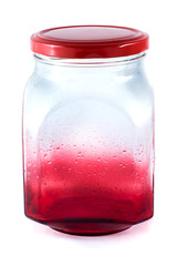 Red colored empty glass screw jar with water drops