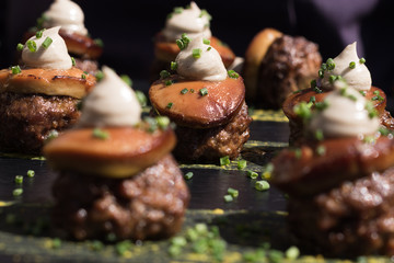 Foie de pato sobre albondiga de ternera sobre bandeja de catering negra de pizarra