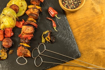Grilled meat on metal needle. Homemade barbecue. Skewers with pieces of raw meat, red, yellow and green bell pepper. Fastfood