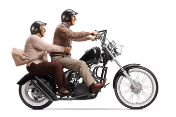 Fototapeta na wymiar Senior couple with helmets riding a custom motrobike