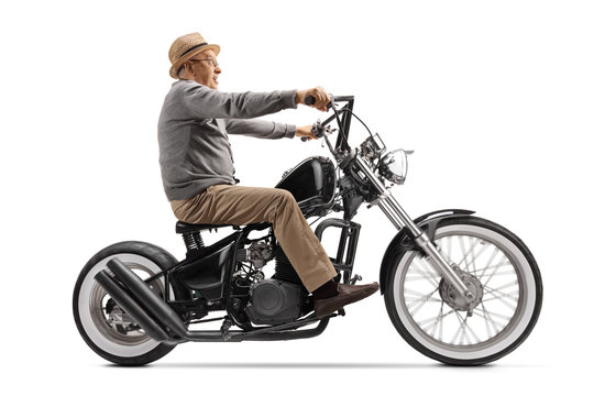 Excited elderly gentleman riding a custom motrobike
