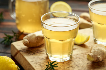 Kombucha Ginger, lemon Tea in glass ,on wooden board. healthy drink