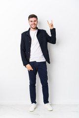 Full body young caucasian man isolated showing a horns gesture as a revolution concept.