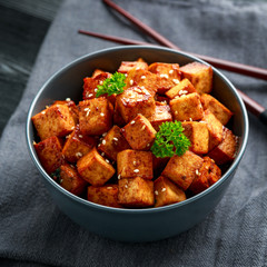 Fried Tofu in a bowl with chopstick and sesame seeds