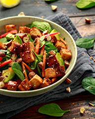 Healthy Vegan Fried Tofu salad with carrot, red bell pepper, spinach and nuts