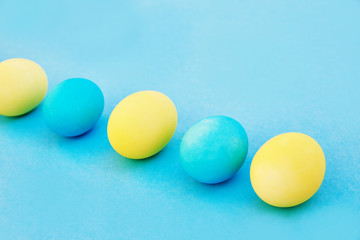 Easter blue and yellow eggs on blue background. Greeting Easter Spring Card