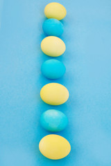 Easter blue and yellow eggs on blue background. Greeting Easter Spring Card