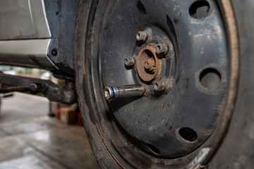 The pneumatic wrench cap attached to the screw on the steel car wheel after it has been replaced.