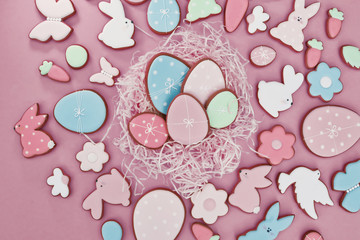 Easter card with gingerbread cookies. Easter spring decorative composition with homemade Easter cookies in form of funny rabbit and eggs on pink background