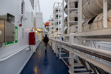 A man walks along the deck of a Gabriella passenger cruise ferry.