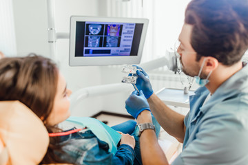 Teeth layout for the dentist with a toothbrush in dentist hands, showing for patient.