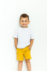 Cute little boy in yellow shorts and white t-shirt