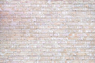 Wall covered with decorative tiles in the form of pieces of bricks.