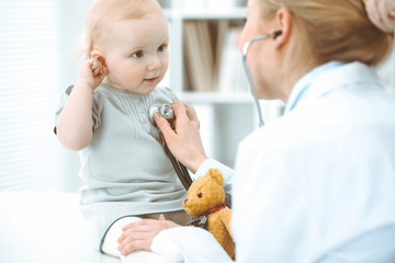 Doctor and patient in hospital. Little girl is being examined by doctor with stethoscope. Medicine concept