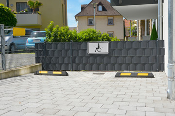 Behinderten-Parkplatz mit Stahlgitter und Hochleistungsfolien-Sichtschutz mit reflektierenden Abstandhaltern an einer Neubau-Wohnanlage
