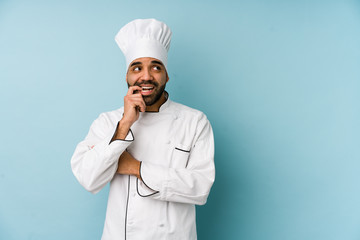 Young latin chef man isolated relaxed thinking about something looking at a copy space.