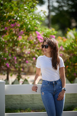 Naklejka premium Smiling woman in sunglasses standing on the street 