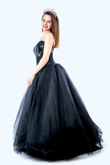 young lady posing in fashion long black dress. Portrait of a stunning young woman posing in black evening dress. Isolated