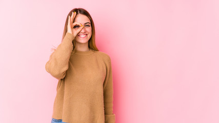 Young caucasian woman isolated on pink background excited keeping ok gesture on eye.