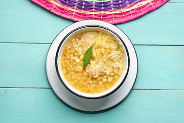 Mexican corn grain boiled also called esquites with cheese and mayonnaise on turquoise background