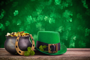 St Patrick's Day hat and pot with gold coins on green twinkling bokeh background