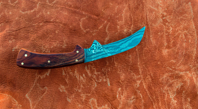 This elk hide fabric has a brownish twinge to the lush lava color to match the cocobolo handle for displaying purposes. Bokeh.