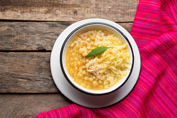 Mexican corn grain boiled also called esquites with cheese and mayonnaise on wooden background