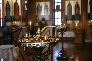 .a burning candle stands on a hanger in a church