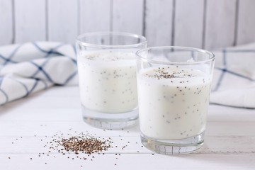 Two servings of fresh natural homemade organic yogurt (ether) in glass glasses on a light background.